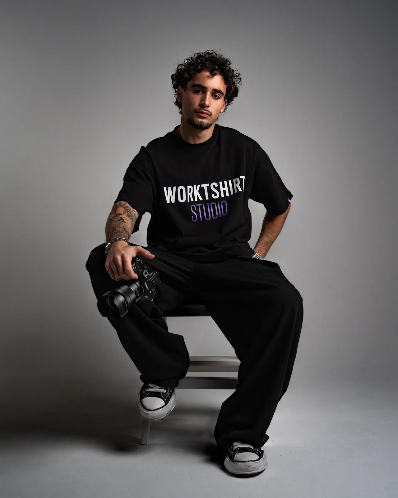 Portrait d'un homme assis en t-shirt Workshirt, fond gris
